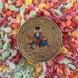 Decorative tin with a nutcracker design surrounded by colorful taffy.