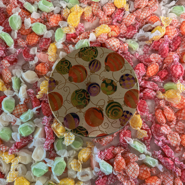 Colorful taffy candies with a decorative tin in the center.